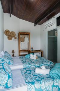 费尔南多 - 迪诺罗尼亚Pousada Sette Mares的一间卧室配有两张带蓝白色床单的床