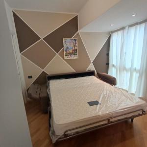 阿拉西奥Appartamento Da Vinci 19的一张位于一个几何墙的房间的床位