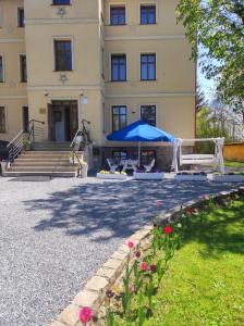 库多瓦-兹德鲁伊Willa Pod Gwiazdami & SPA的一座带蓝色伞和一些鲜花的建筑