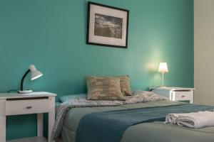 普拉亚欧尼恩Los Palos Ribera Norte的一间蓝色的卧室,配有床、桌子和灯