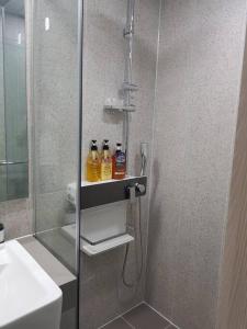 束草市Sokcho Summitbay 1701 "Ocean View"的浴室设有淋浴,架子上装有两瓶水