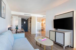 阿利坎特Suites del Mar by Melia的客厅配有蓝色的沙发和平面电视。