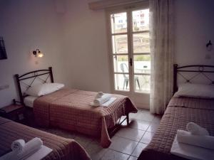 伊奥斯乔拉Nikolas ios Village的酒店客房设有两张床和窗户。