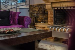 沃洛斯Dana's Luxury Maisonette的客厅配有紫色沙发和壁炉