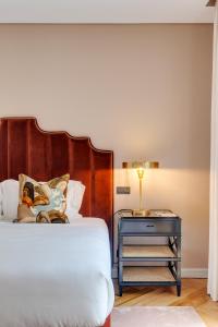 波尔图Portie Deluxe Suites by DA'HOME的一张带木制床头板和蓝色床头柜的床