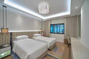 迪拜迪拜君悦公寓的酒店客房设有两张床和窗户。