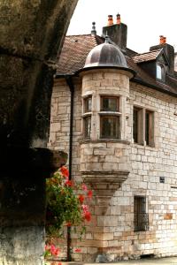 博姆雷达姆Maison La Tourelle的一座古老的石头建筑,设有窗户和鲜花