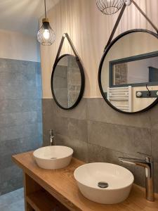 博姆雷达姆Maison La Tourelle的浴室设有水槽和墙上的两面镜子