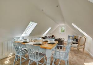 RoughtonBlackberry Cottage的一间带桌子和蓝色椅子的用餐室
