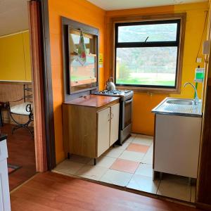 百内三塔廷德尔湖山林小屋的厨房配有水槽、炉灶和窗户。