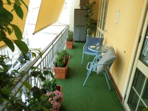 夸尔图-圣埃莱娜A casa di nonna的阳台配有桌椅和植物
