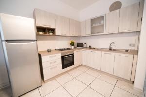 加利波利Sunset home Baia Blu的厨房配有白色橱柜和冰箱。