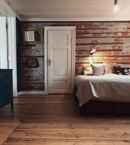 皮特奥Pensionatet的一间卧室设有一张床和木墙