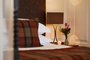 利明顿麦克唐纳艾尔莫斯苑度假村的一间卧室配有一张带枕头和灯的床