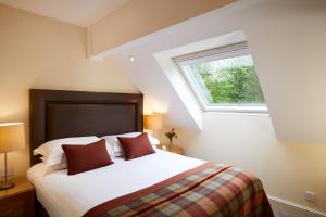 利明顿麦克唐纳艾尔莫斯苑度假村的一间卧室设有一张大床和窗户