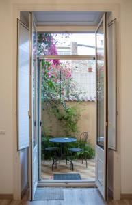 卡塔尼亚B&B Ambitious的滑动玻璃门通向带桌子的庭院