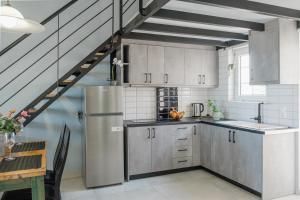 普拉塔尼亚斯米拉马尔公寓的厨房配有不锈钢冰箱和楼梯