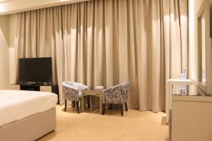 麦纳麦Capital O 111 Infinity Suites的酒店客房带一张床、一张桌子和椅子