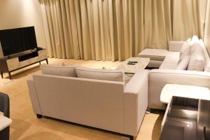 麦纳麦Super OYO Capital O 111 Infinity Suites的客厅配有白色沙发和平面电视。