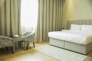 麦纳麦Super OYO Capital O 111 Infinity Suites的一间卧室配有一张床、一张书桌和一个窗户。