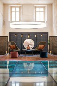 布拉格布拉格文华东方酒店的一个带两把椅子和壁炉的房间的游泳池