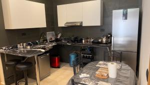 拉巴特Cozy Appartement in a Villa close to Mahaj Riad Rabat的厨房配有水槽、冰箱和桌子