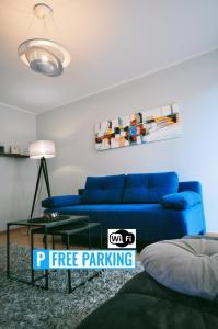 克拉科夫Aquapark with private garage by JoApart的客厅配有蓝色的沙发和桌子