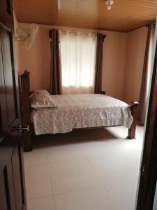 奎波斯城Central 3 Bedroom Quepos Home的一间小卧室,配有床和窗户