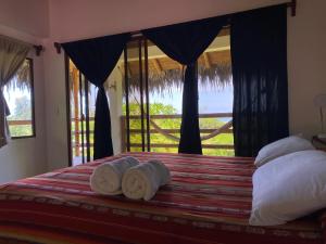 Las TunasHosteria Guachapeli的一间卧室设有一张床,享有海景