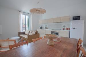 蒙彼利埃NOCNOC - L'Amarelo - Charmant T4 avec terrasse au calme的厨房以及带木桌的用餐室。