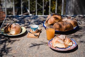 阿谢亚Villa Santa Sofia的一张桌子,上面放着两盘面包和一杯橙汁