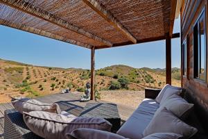 塔维拉Portugals Infinity - Fantástica casa de campo com vista de mar的带沙发的门廊,享有山景