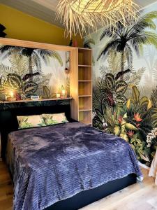 Saint-Aignan-Grand-LieuCopacabana TINY HOUSE studio terrasse jardin的一间卧室配有一张带植物壁画的床