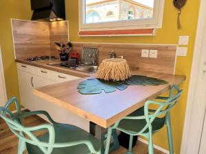 Saint-Aignan-Grand-LieuCopacabana TINY HOUSE studio terrasse jardin的厨房配有木桌和两把椅子