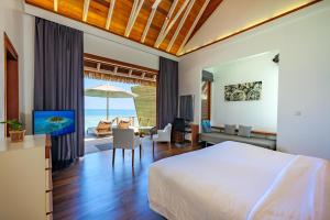 希曼杜岛马尔代夫坎德鲁度假酒店的一间卧室设有一张床和一间客厅。