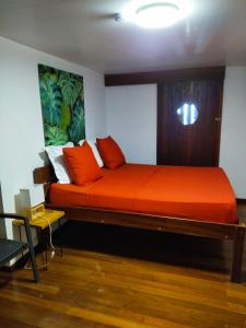 BourdaLE CHALET DOMAINE DU ROCHER的一间卧室配有一张带橙色床单的大床