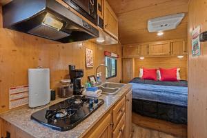 约书亚树JT Village Campground - Sun Ray的一个小房子里一个带水槽的厨房和一张床