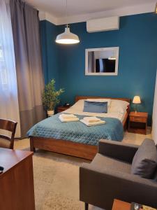 卢布林地区托马舒夫斯塔罗波尔斯卡酒店的蓝色的卧室配有床和沙发