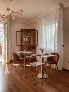 里米尼Villa Maldestra的一间带2张桌子和椅子的用餐室