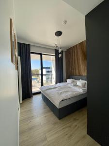 洛格沃Rogowo Prestige Shellter的一间卧室设有一张床和一个大窗户