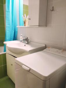 尼亚普拉莫斯Dimis Apartment的白色的浴室设有水槽和镜子