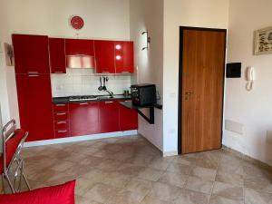 圣特雷莎加卢拉Casa Antonella的一间设有红色橱柜和门的小厨房