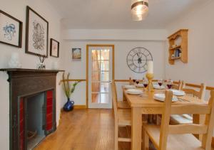 赫彻姆Staithe Cottage的一间带桌子和壁炉的用餐室