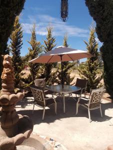 恩塞纳达港Casa Campo Rancho Villarino的桌椅、雨伞和喷泉