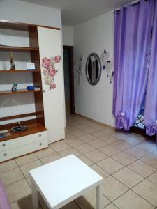 菲乌吉Fiuggi Appartamento Turistico的客厅配有紫色窗帘和白色桌子