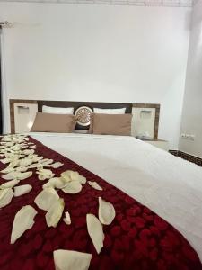 吉布提Haramous Guest House的红色毯子上一张带白色花的床铺