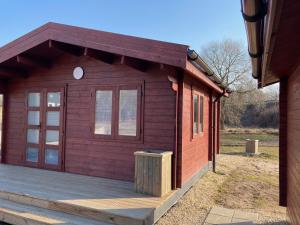拉脱维亚WOMOCAMP Holzhütte 1的小木屋设有木制甲板