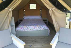 科隆布雷斯Camping Colombres的帐篷内一间卧室,配有一张床