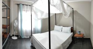 利文斯顿Kalahari Sand Ridge Inn的一间卧室设有四柱床和窗户。