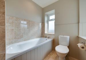 赫彻姆The Old Bank Studios 3B的浴室配有白色浴缸和卫生间。